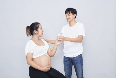 Young couple standing against white background