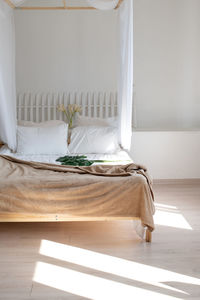 Cozy bright bedroom in white and beige colors. a bed with white linens in the morning sun. interior