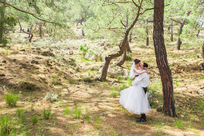 Woman standing by plants in forest