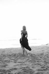 Rear view of woman standing at beach