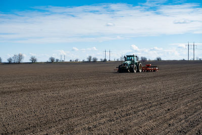 Tractor on agricultural field against sky