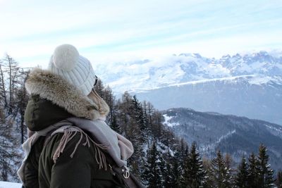 Rear view of girl in snow against sky