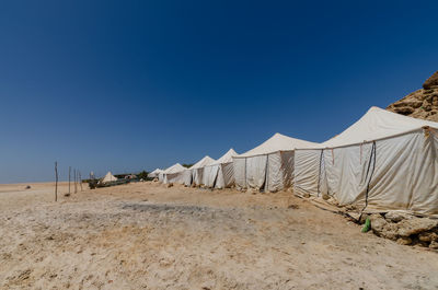 Panoramic view of desert against clear blue sky