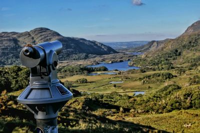 Coin operated binoculars against river and mountain