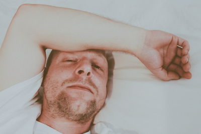 High angle portrait of mid adult man relaxing on bed at home