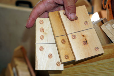 Close-up of man holding wooden dominoes