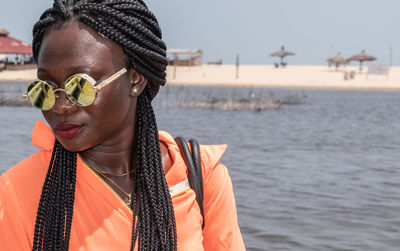Africa woman with round sunglasses is waiting for a boat in sunny ghana