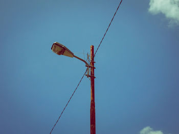 Low angle view of crane against blue sky