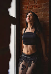 Young woman standing against wall