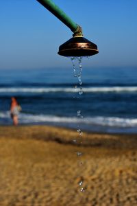 Water drops on beach against sky