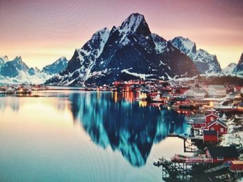 Scenic view of lake by snowcapped mountains against sky