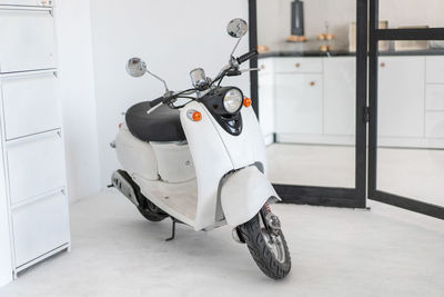 White motor scooter against wall