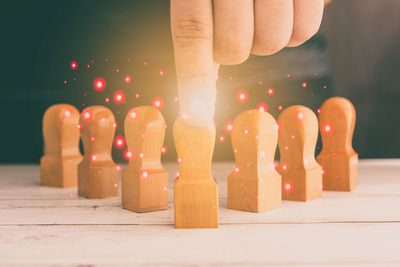 Close-up of hand holding illuminated candles on table