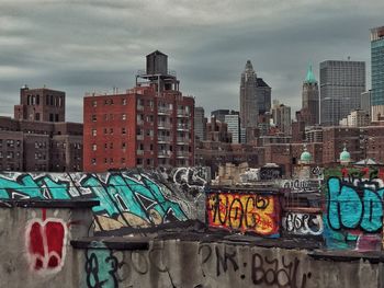 Graffiti on city against sky