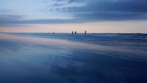 Scenic view of shore and sea against cloudy sky