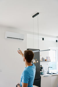Rear view of woman standing against wall