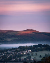 Townscape and mountains against sky during sunset