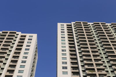 Low angle view of modern building against clear blue sky