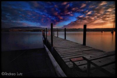 Pier over sea against sky during sunset