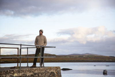 Man standing by sea against sky