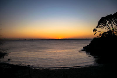 Scenic view of sea against clear sky at sunset