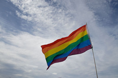 Low angle view of rainbow flag against sky