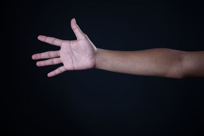 Close-up of woman hand over black background