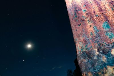 Low angle view of moon against blue sky