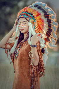 Young woman in traditional clothing standing on field