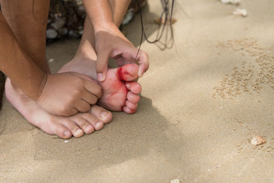 Low section of baby feet on sand