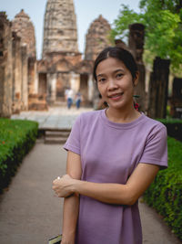 Woman wearing purple dress and old temple at sukhothai, thailand in march 13 2021