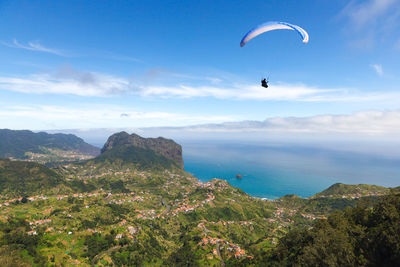 Low angle view of person paragliding against sky