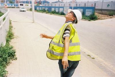 Side view of man standing on footpath