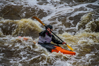 Man surfing on boat in river