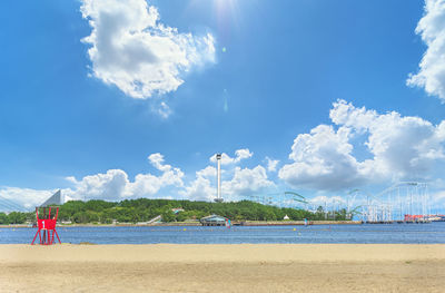 Rear view of man on beach against blue sky