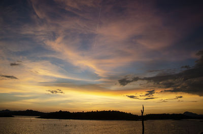 Scenic view of dramatic sky over lake during sunset