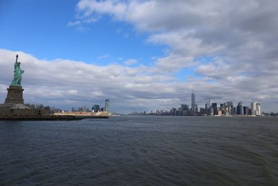 Buildings in city against cloudy sky