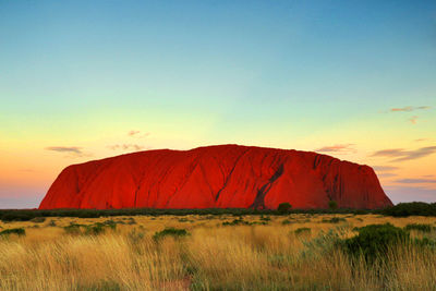 Rock formations on landscape against sky during sunset