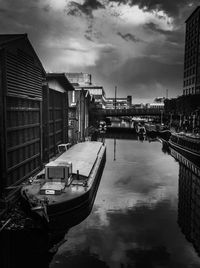Boats moored in city against sky