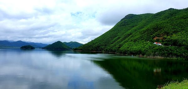 Scenic view of lake by mountains against sky