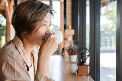 Young woman drinking coffee at cafe