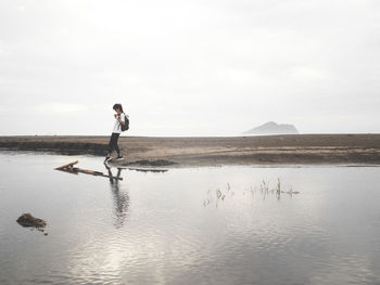 Man standing on beach against sky