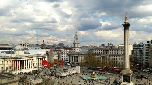 Nelson column at trafalgar square in city against cloudy sky