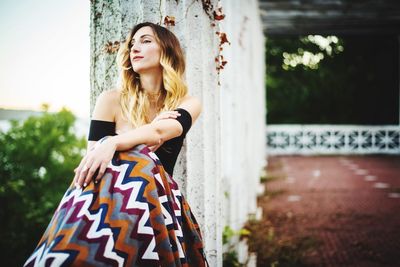 Young woman standing on tree trunk