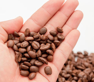 Close-up of hand holding coffee beans
