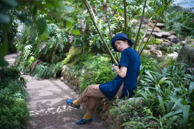 Full length side view of man sitting in park