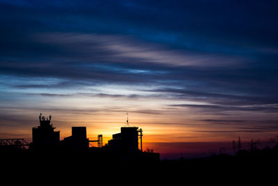 Silhouette city against sky at sunset