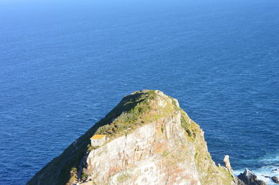 High angle view of rock formation in sea against blue sky