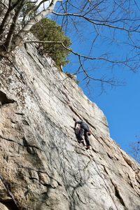 Low angle view of man climbing rock formation