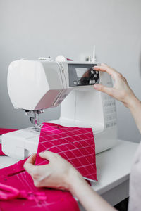 Cropped hands of person using sewing machine